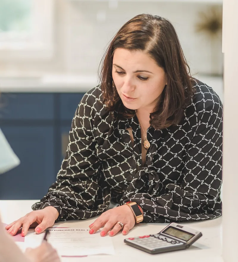 An adviser and a client discuss documents in a bright, relaxed setting.